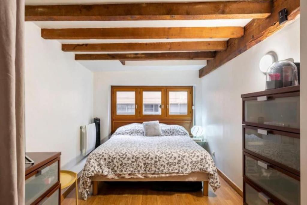 une chambre avec un lit et un plafond en bois dans l'établissement Duplex atypique loft Lyon 6, à Lyon