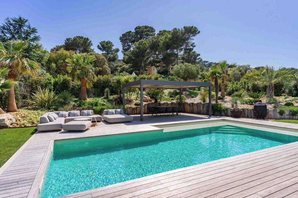 une piscine avec des chaises et un gazebo dans l'établissement Villa Palma Giens - Vue Mer Panoramique -Piscine Chauffée Mai à Septembre- 4 chambres -Garage, à Hyères