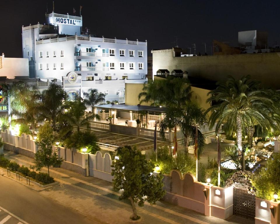 un gran edificio blanco con palmeras y luces en Casa Quiquet, en Beniparrell