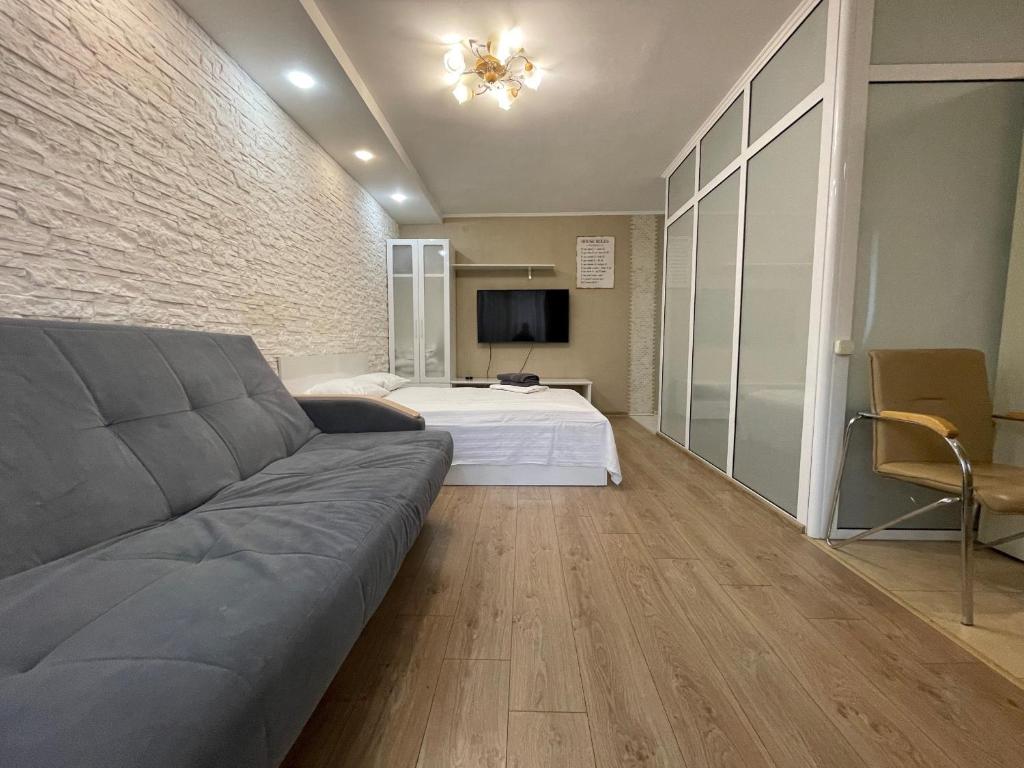 a living room with a couch and a bed at Квартира с гостиничным сервисом бизнес-класса с большой ванной и Smart-TV in Petropavlovsk