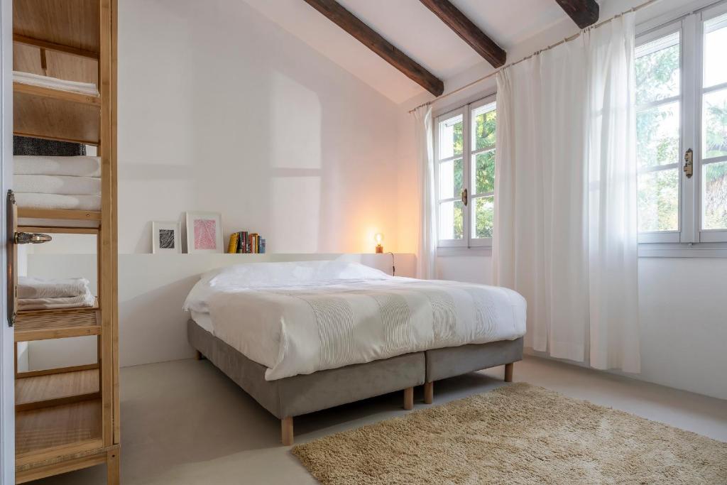 a white bedroom with a bed and a book shelf at Charming loft in Venetian Villa in Noale