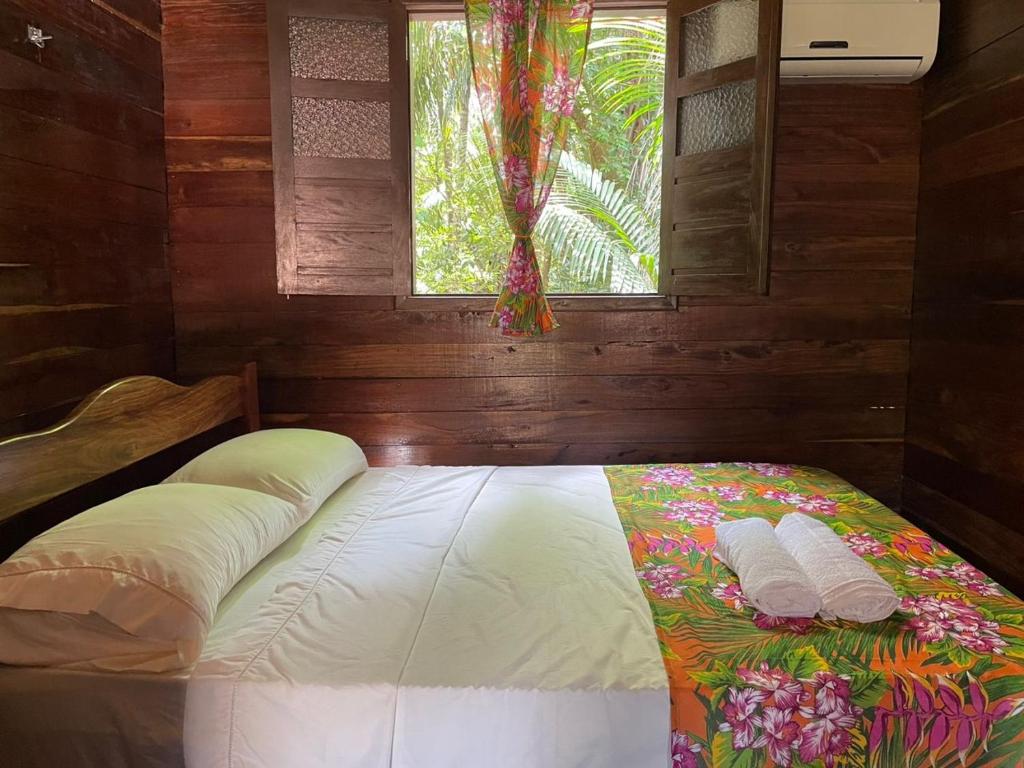 a bed in a room with a window at Casa da mata marajó in Salvaterra