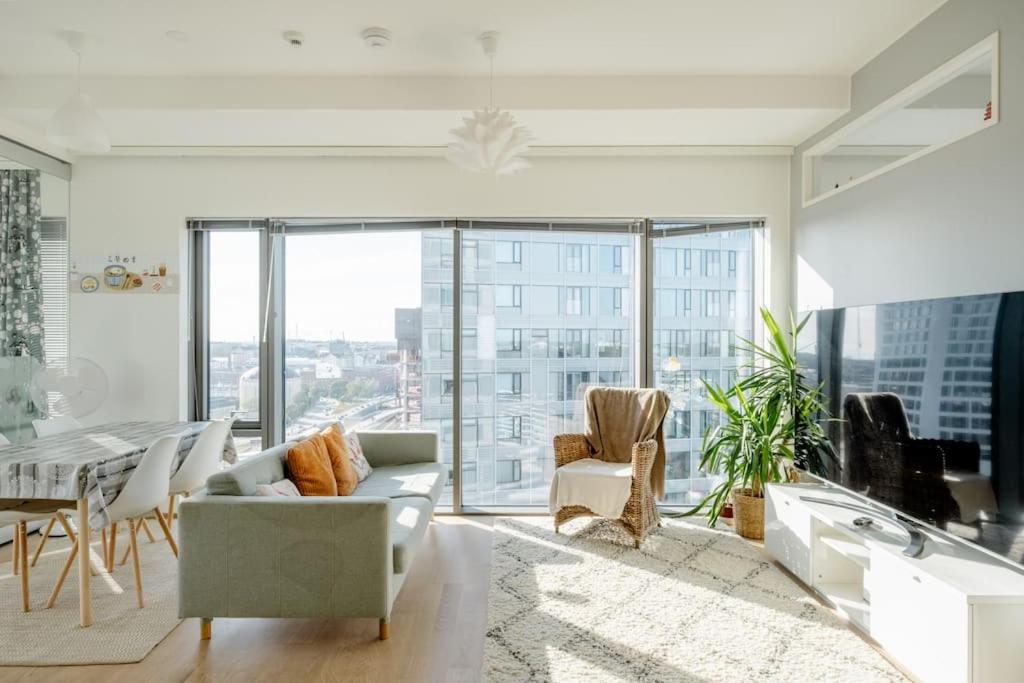 a living room with white furniture and a large window at Fabulous Morden Apartment in Helsinki in Helsinki