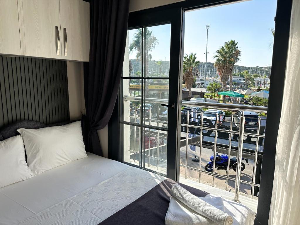 a bedroom with a bed and a large window at Marina Lora Butik Otel in Seferihisar