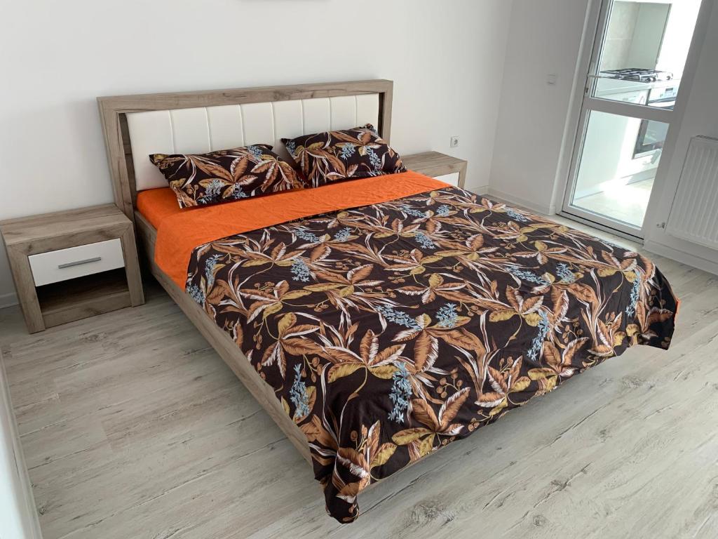 ein Schlafzimmer mit einem Bett mit einer orangefarbenen Decke in der Unterkunft Residence Tineretului in Roşu