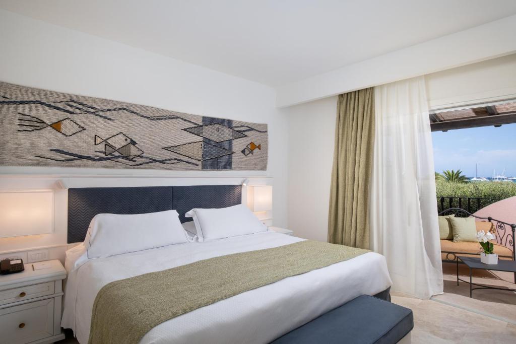 a bedroom with a large bed and a window at Hotel Abi d'Oru in Porto Rotondo