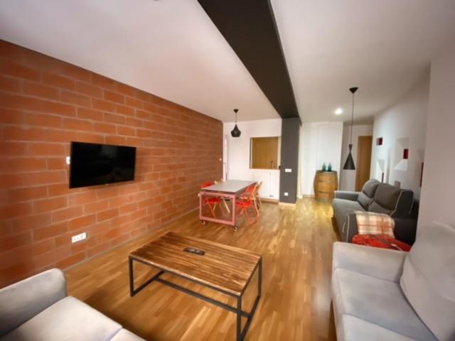 sala de estar con sofá y pared de ladrillo en Apartamentos Laurel, en Logroño