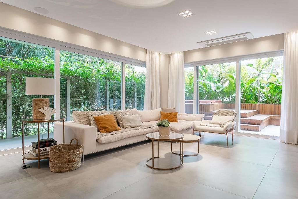 uma sala de estar com um sofá branco e algumas janelas em Garden | Churrasqueira | Piscina Condomínio #JA27 em Florianópolis