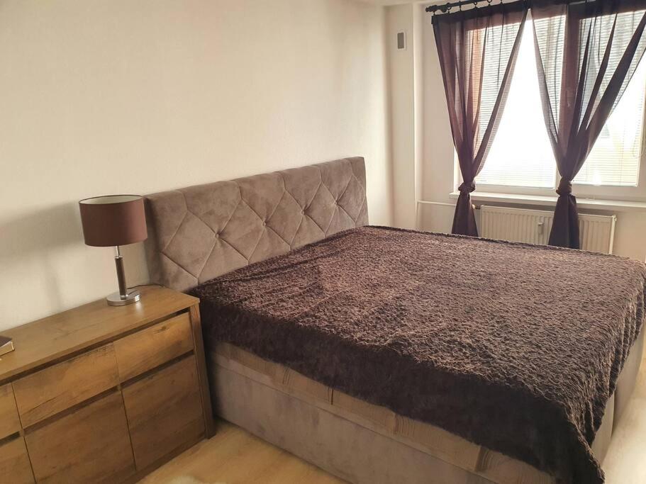 a bedroom with a bed and a dresser and a window at Veľký Apartmán 2-4 osôb v srdci Tatier in Liptovský Hrádok