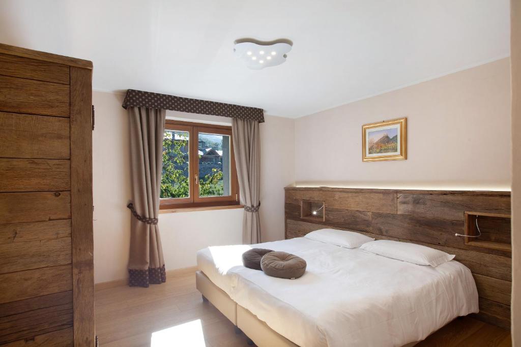 een slaapkamer met een bed met een houten hoofdeinde en een raam bij La Vigne De Papagran App3 in Aosta