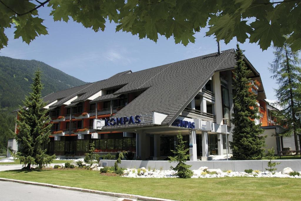 ein großes Gebäude mit schwarzem Dach in der Unterkunft Hotel Kompas in Kranjska Gora