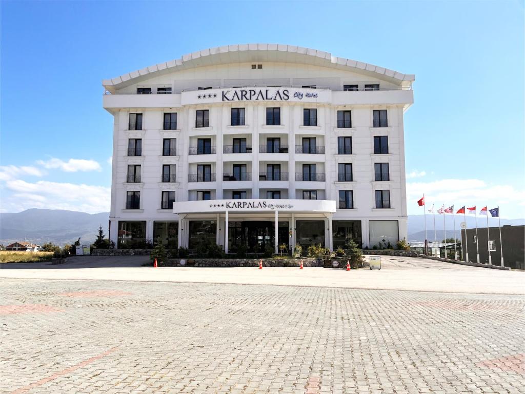a large white building with a sign on it at Karpalas City Hotel & Spa in Bolu