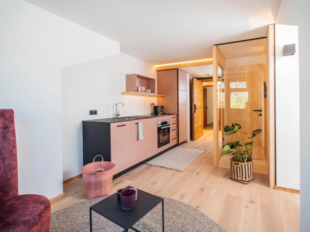 a kitchen and living room with a couch and a table at Apartment Greta by Interhome in Stams