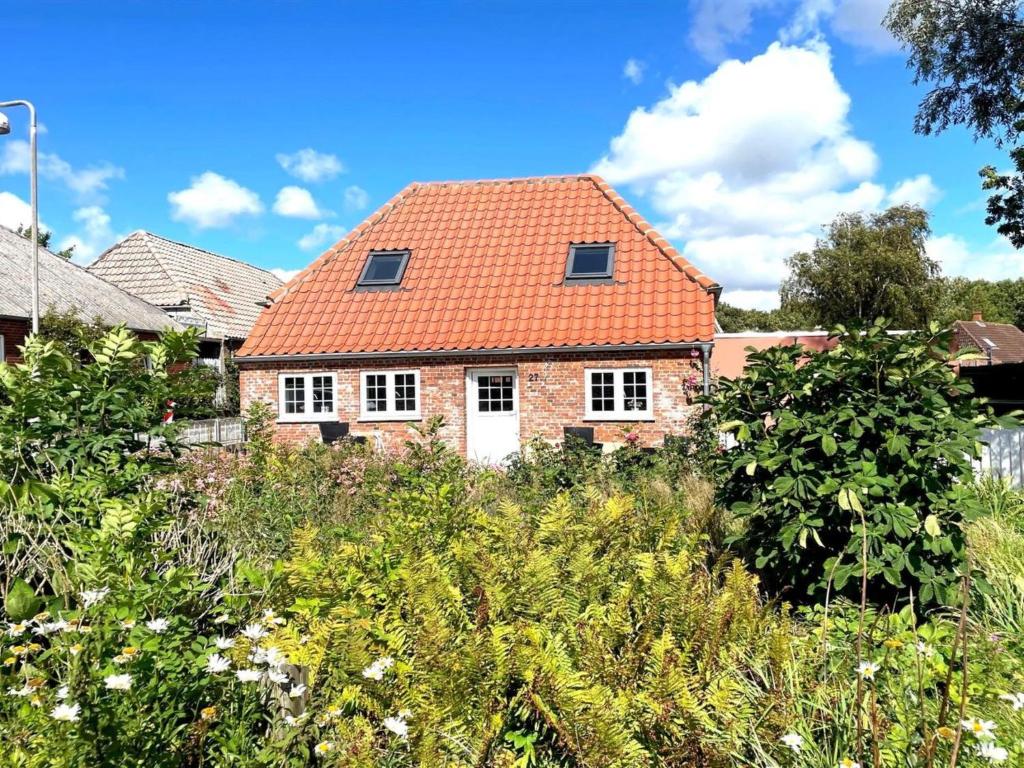 een stenen huis met een oranje dak bij Holiday Home Arnora - 48km from the sea in Western Jutland by Interhome in Højer