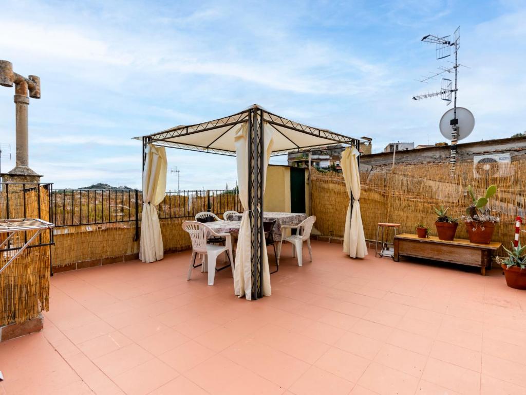 een tuinhuisje met tafels en stoelen op een patio bij Apartment Elisa by Interhome in Imperia