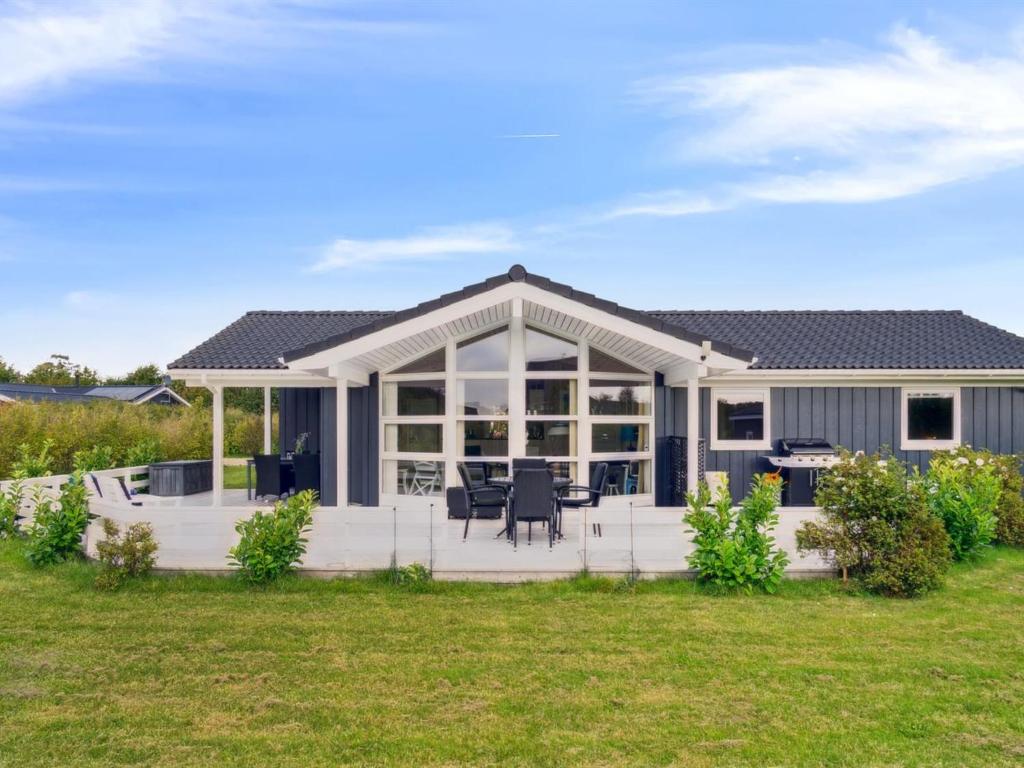 een groot huis met een patio en een gazon bij Holiday Home Skaghi - 500m from the sea in Sealand by Interhome in Føllenslev