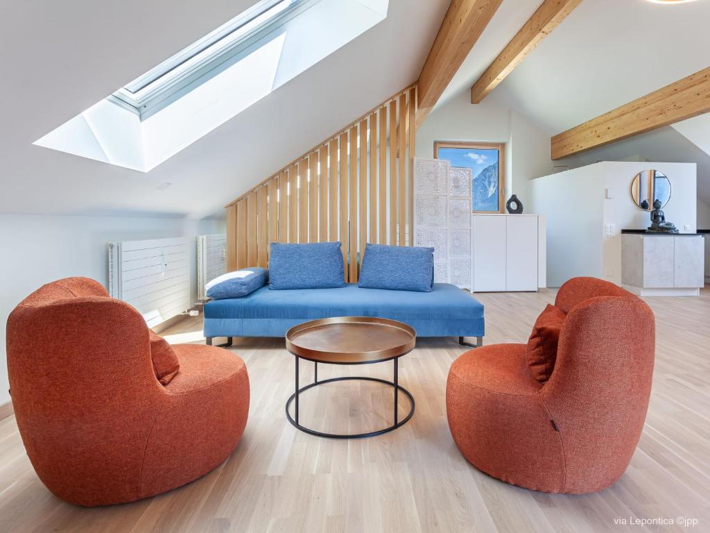 uma sala de estar com duas cadeiras e um sofá em Apartment Casa Lepontica-2 by Interhome em Leontica