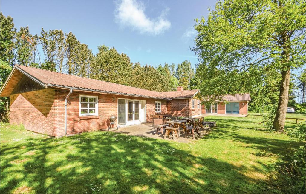 a brick house with a picnic table in a yard at 8 Bedroom Nice Home In ster Assels in Sillerslev