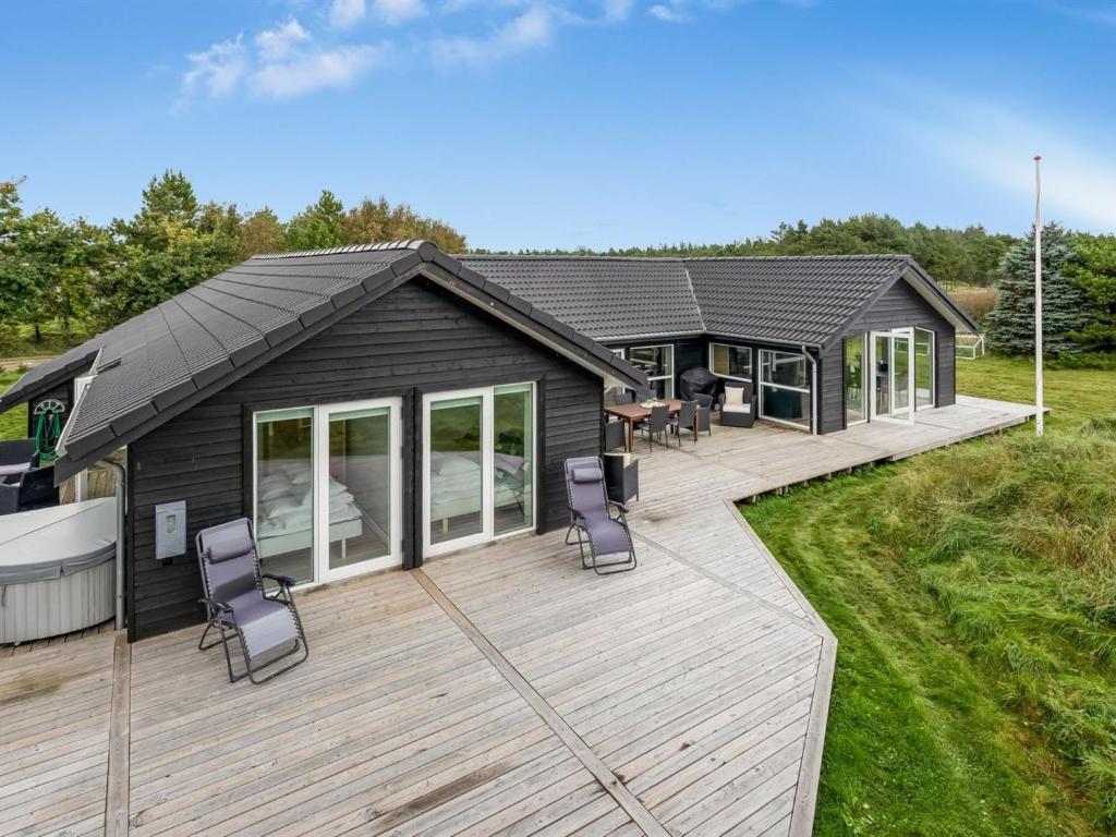 バイアス・スタンにあるHoliday Home Christl - 1km from the sea in Western Jutland by Interhomeのデッキと椅子が置かれた家