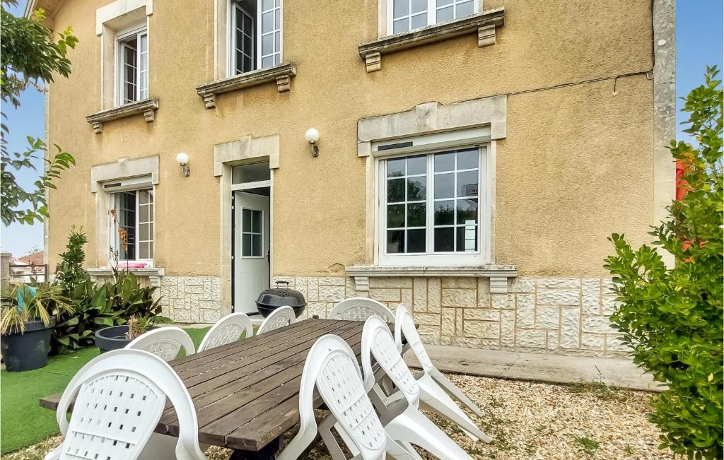 a wooden table and chairs in front of a building at 4 Bedroom Gorgeous Home In Jarnac in Jarnac