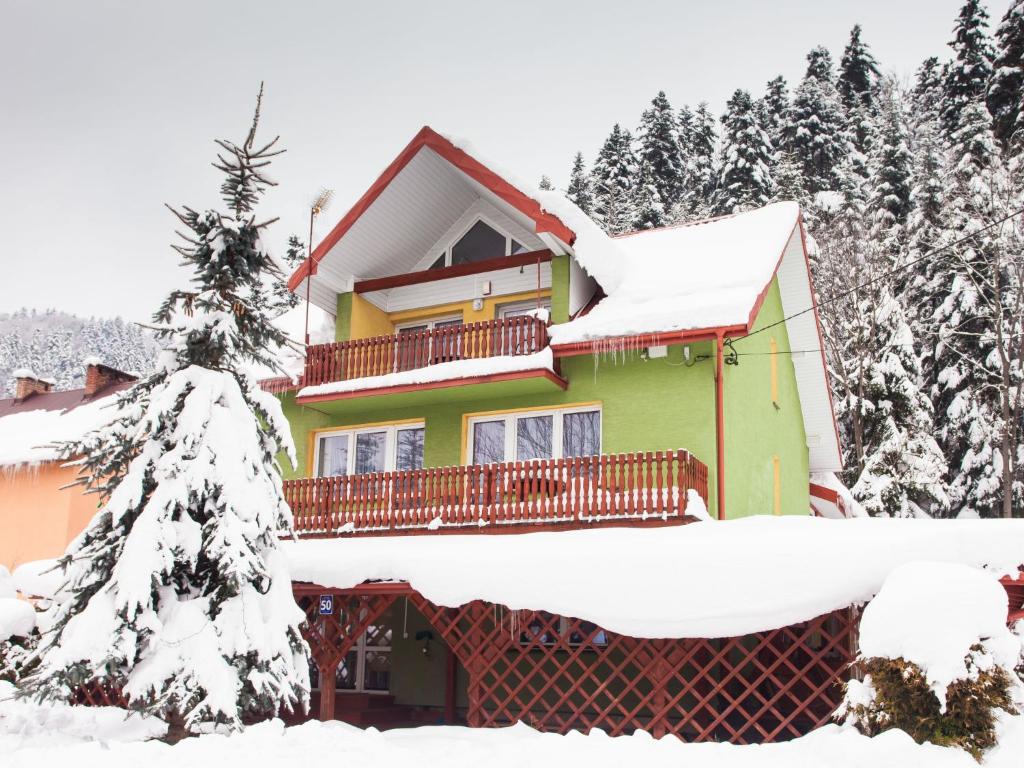a house covered in snow with snow covered trees at Holiday Home Antoś by Interhome in Baligród