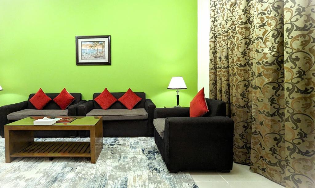 a living room with a black couch and red pillows at City Tower Hotel in Fujairah