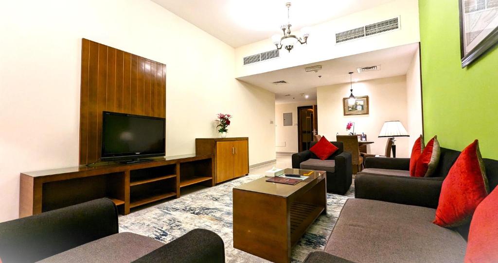 a living room with couches and a flat screen tv at City Tower Hotel in Fujairah