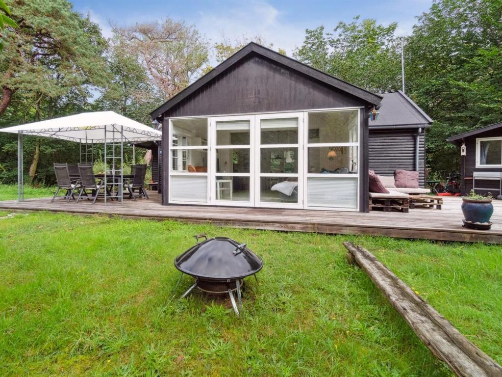 una casa con una parrilla en el patio en Holiday Home Lucie - 50m from the sea in Bornholm by Interhome en Rønne