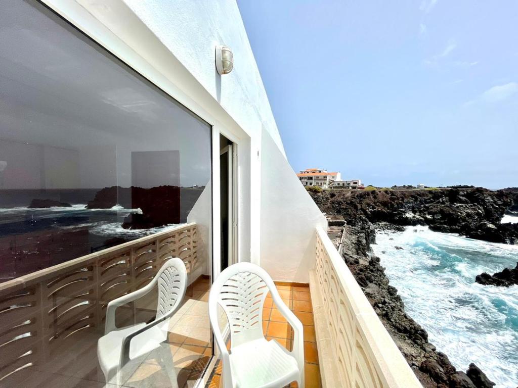 balcone con 2 sedie e vista sull'oceano di Apartamento vista mar, a escasos metros de la playa a Tamaduste