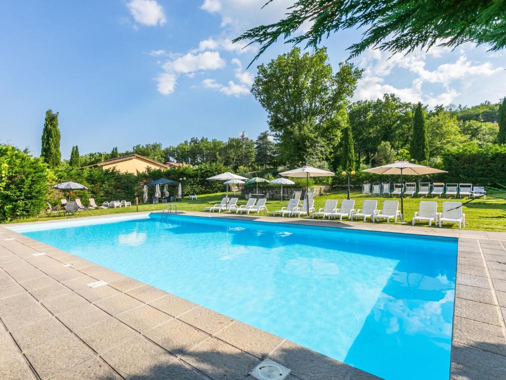 ein großer Pool mit Stühlen und Sonnenschirmen in der Unterkunft Holiday Home Le Muricce by Interhome in Badia Agnano