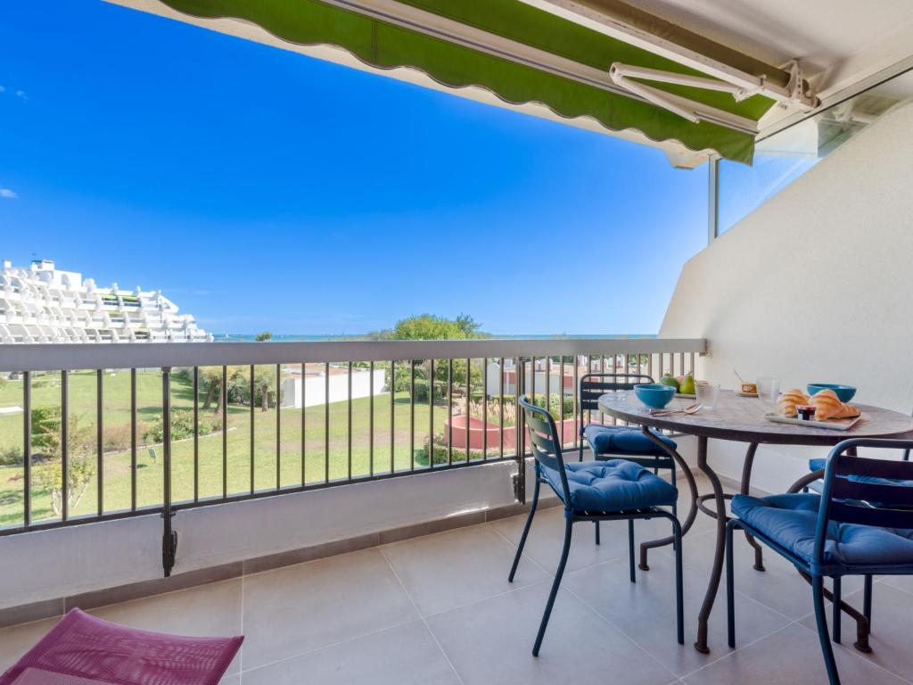 un balcon avec une table et des chaises et une vue dans l'établissement Apartment Les Grenadines-6 by Interhome, à La Grande Motte