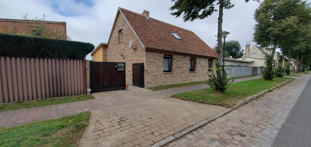 a brick house with a gate on a street at Haus Oderbruch in Neulewin