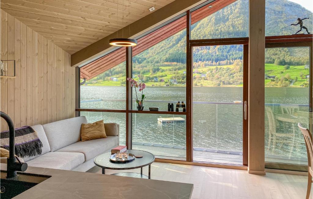 a living room with a couch and a large window at Awesome Home In Straumgjerde With Kitchen 