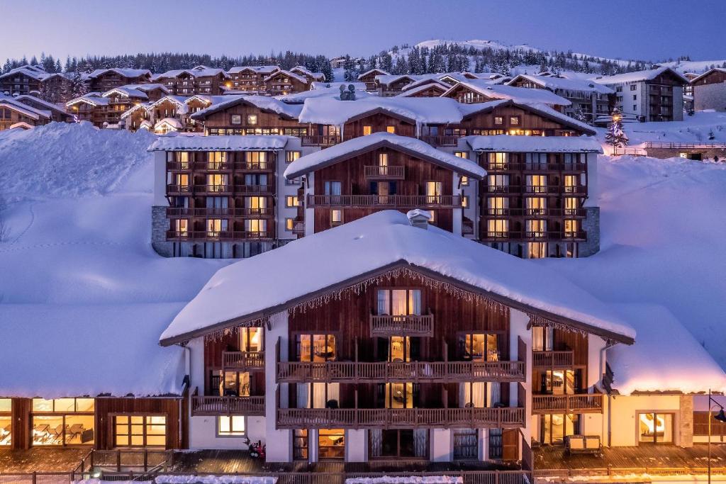 a resort in the snow with snow covered buildings at ILY Hotels La Rosiere in La Rosière