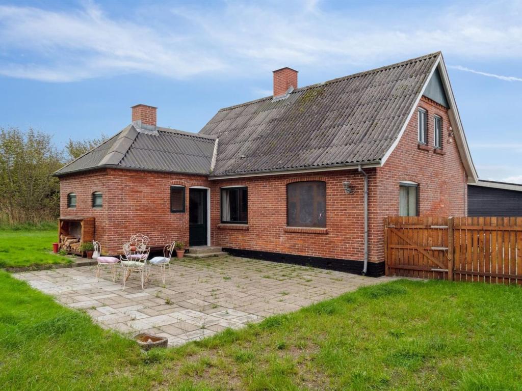 a brick house with a fence and a yard at Holiday Home Quiana - 4km from the sea in NW Jutland by Interhome in Torsted