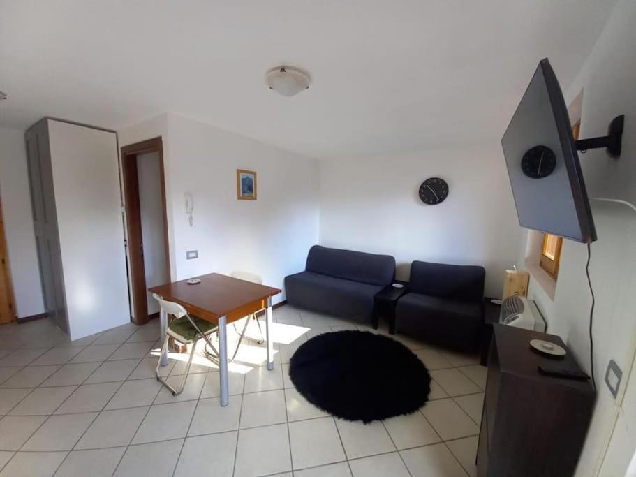 sala de estar con sofá y mesa en CASA TATA -Appartamento vista mozzafiato en Lizzola Alta