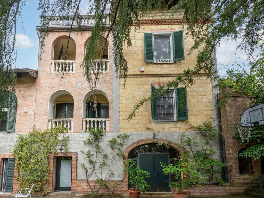 un antiguo edificio de ladrillo con puertas y ventanas verdes en Holiday Home Il Roccolo by Interhome, en Ottiglio