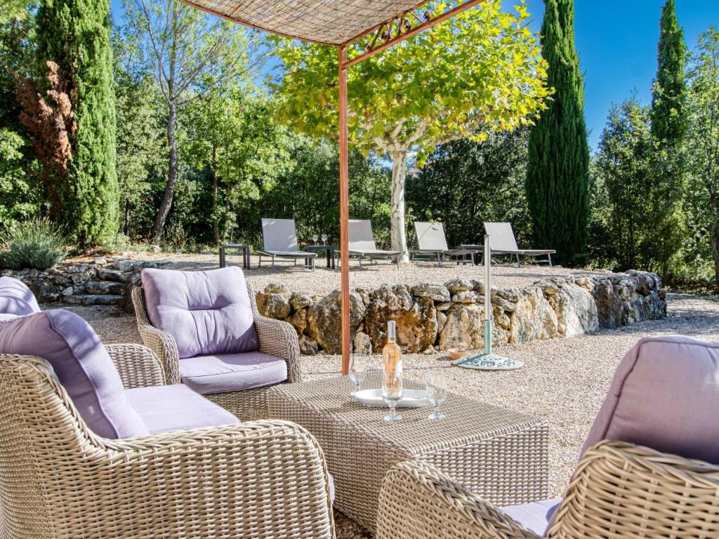 patio z krzesłami i stołem z parasolem w obiekcie Holiday Home Villa 10 by Interhome w mieście Nans-les-Pins