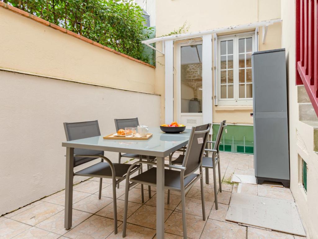 une table et des chaises sur le patio d'une maison dans l'établissement Apartment Mirabeau by Interhome, à Deauville