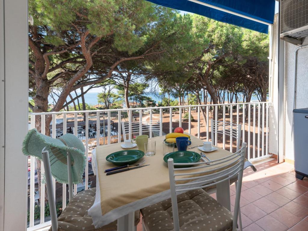 einen Tisch und Stühle auf einem Balkon mit Meerblick in der Unterkunft Apartment La Pineta by Interhome in Casa SantʼEugenia
