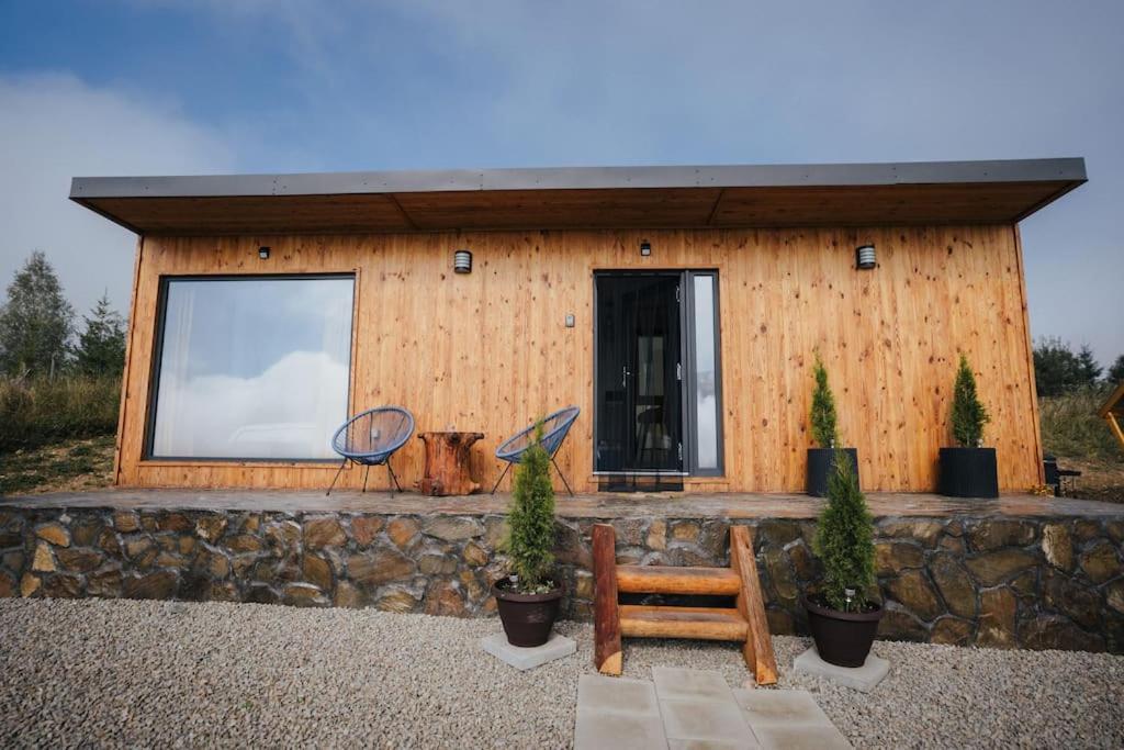 a log cabin with a bench in front of it at Cozy Cube - tiny house 