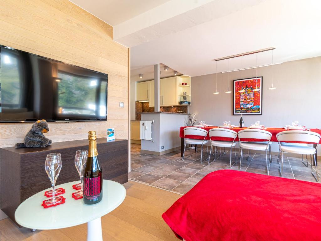 a living room with a table with a bottle of wine at Apartment Le Shamrock - Le Lac-6 by Interhome in Tignes
