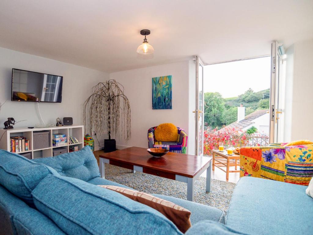 a living room with blue couches and a table at Apartment Helland by Interhome in Pentewan
