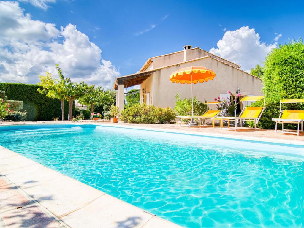 une piscine avec des chaises et un parasol à côté d'une maison dans l'établissement Holiday Home Villa 15 by Interhome, à Nans-les-Pins