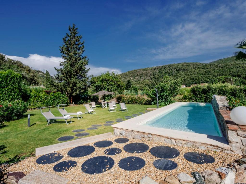um quintal com uma piscina e espreguiçadeiras em Villa Serena by Interhome em Rio Marina