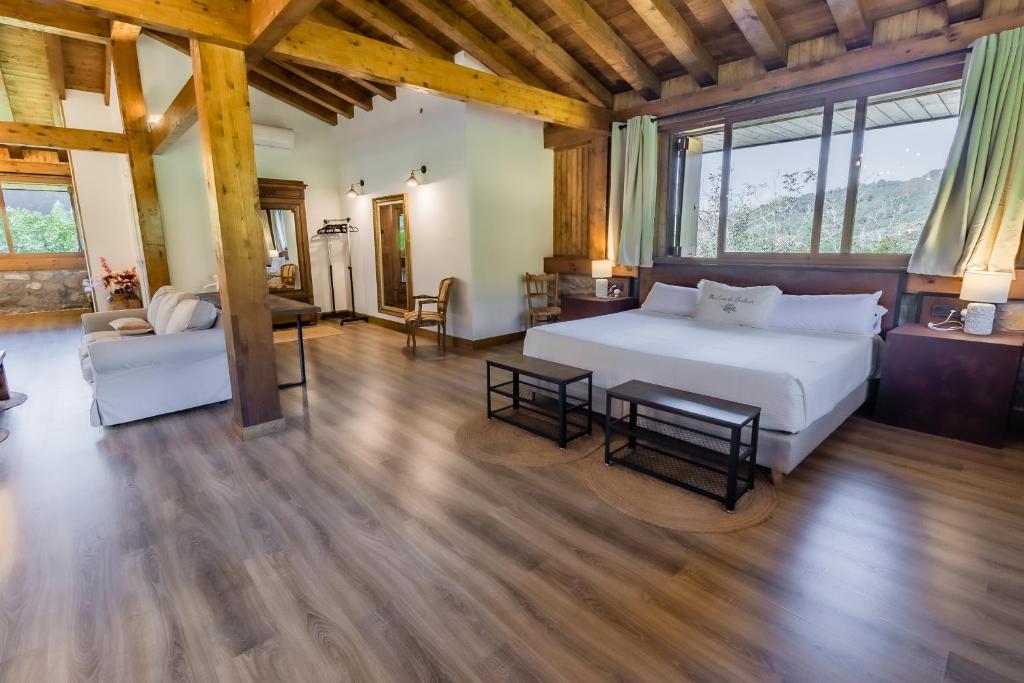 a bedroom with a large white bed and a couch at Fagoaga dorretxea in Ergoyen