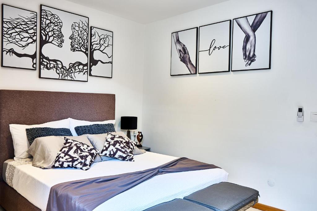 ein Schlafzimmer mit einem Bett mit vier Bildern an der Wand in der Unterkunft Lc Apartments - Sunshine in Santa Maria