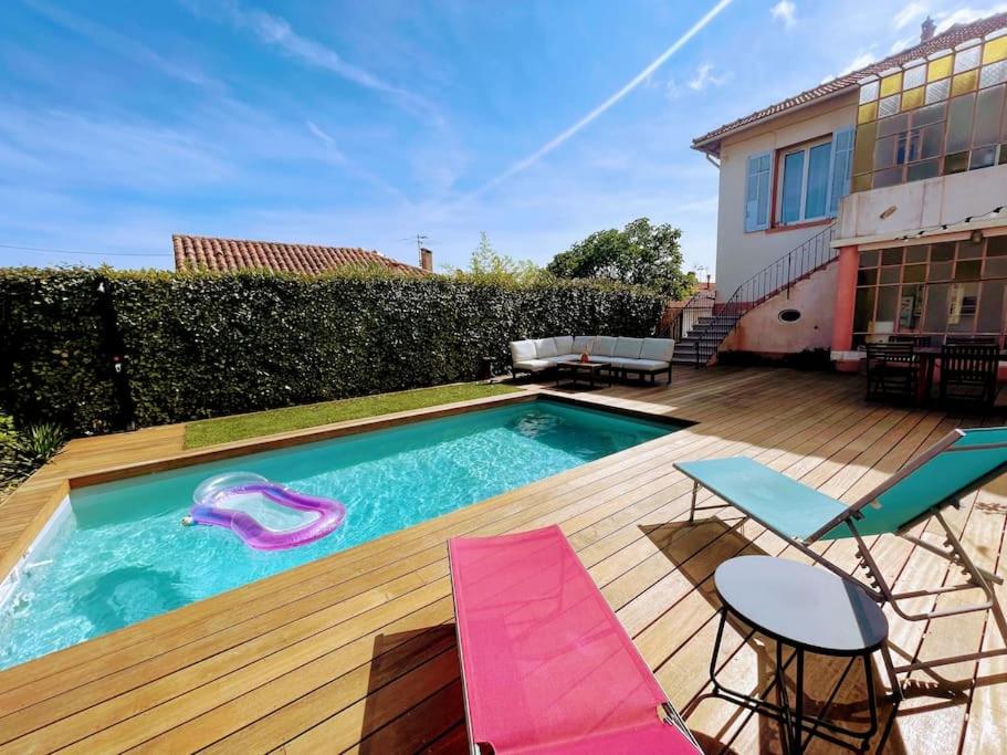 un patio trasero con piscina, sillas y una casa en T2 au calme - Stationnement facile - Proche gare en Toulon