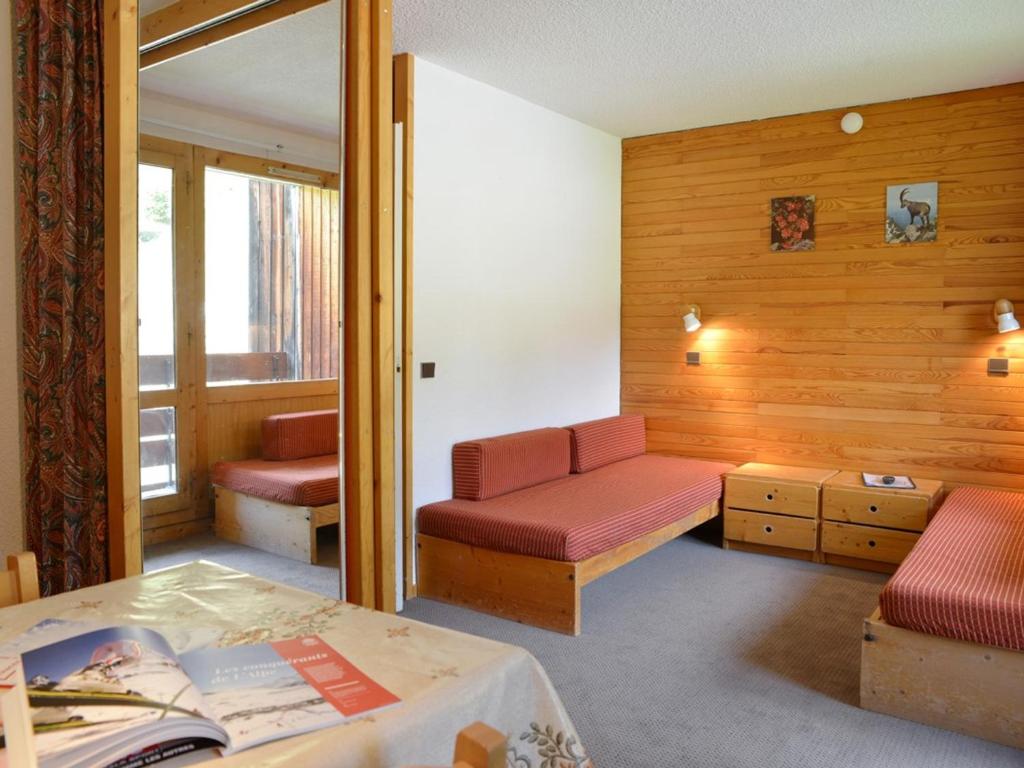 une chambre avec un lit, un canapé et une fenêtre dans l'établissement Studio lumineux au pied des pistes avec balcon, parking et animaux admis - FR-1-181-2224, à La Plagne Tarentaise