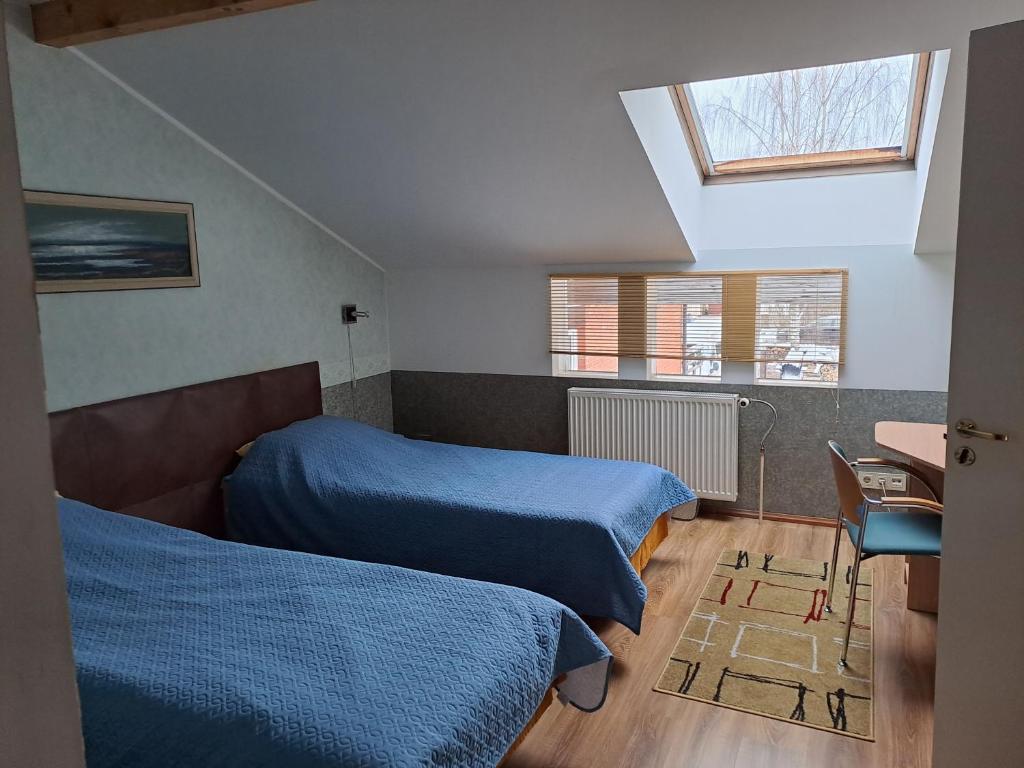 - une chambre avec 2 lits et une fenêtre dans l'établissement Rähni Maja, à Põlva